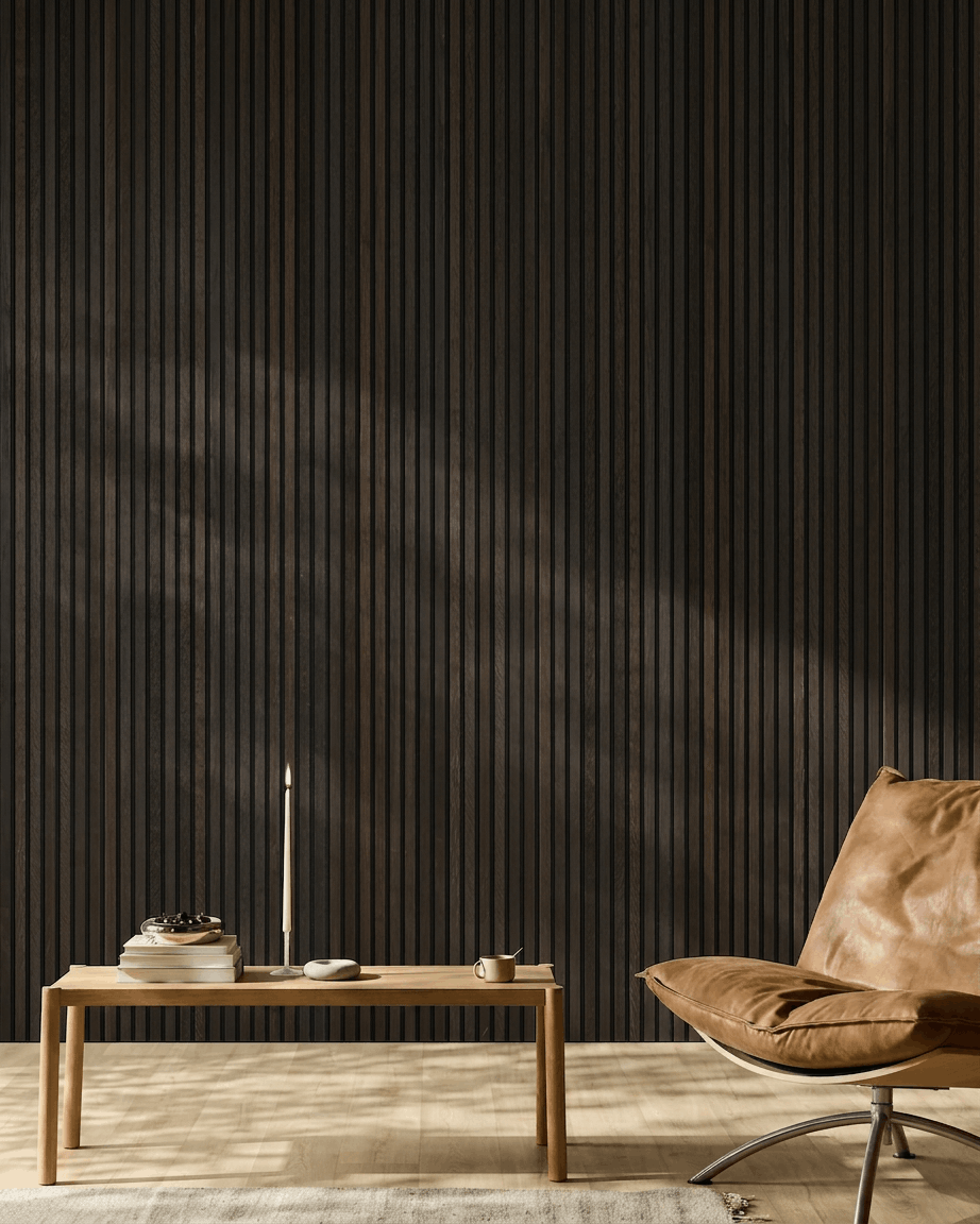 Minimalist room featuring a brown leather chair, coffee table, and decor in front of a WoodUpp Akupanel Rustic Smoked Oak acoustic wood panel wall.